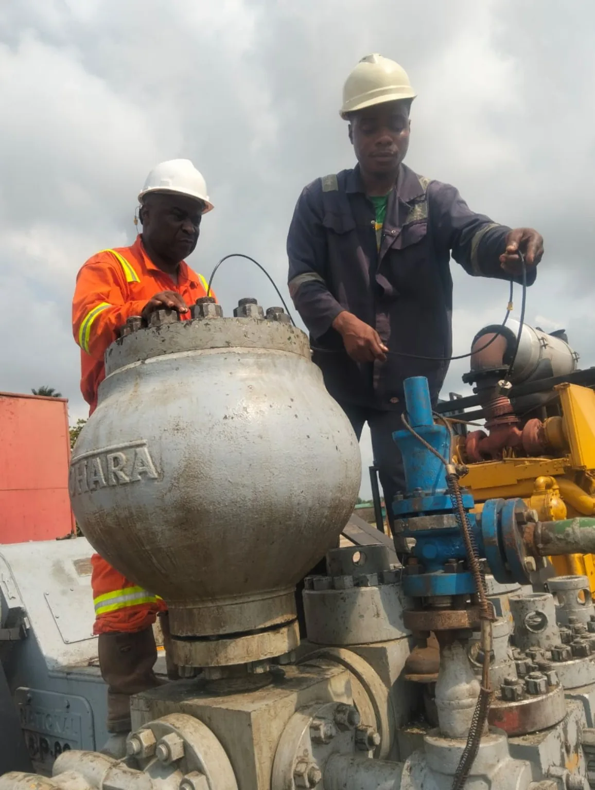 Two technicians maintaining industrial export pump equipment
